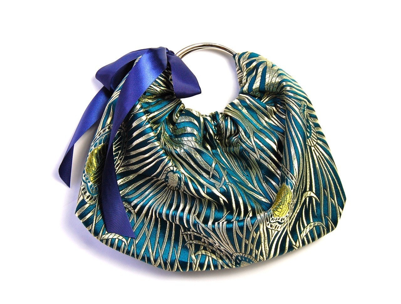 The COQUETTE Wristlet Clutch in teal and navy peacock