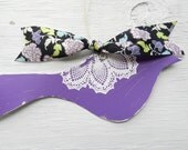 Purple bird with white doily design and colorful ribbon to hang