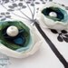 A pair of handmade innocent ivory and something blue flowers filled with a large fresh water pearl and Swarovski crystal. For your wedding, favorite shoes and life.