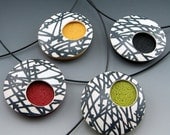 Modern polymer clay pendant necklace with abstract black and white design on black choker neckwire