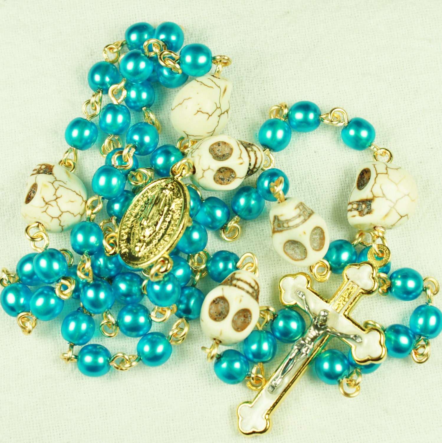 Muertos Skull Rosary in Gold with Turquoise Blue Glass Pearls and bone White Stone Skulls
