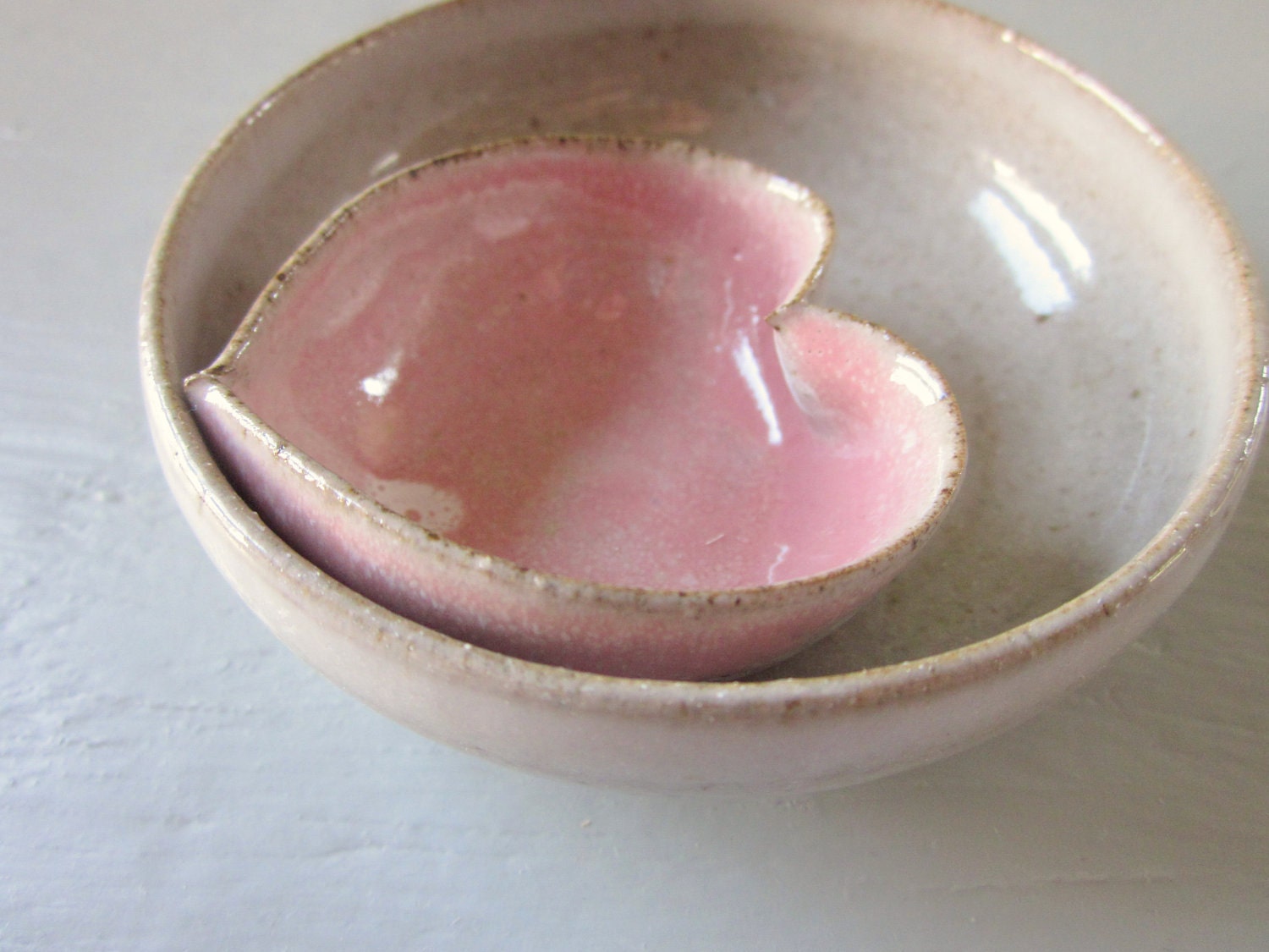 pink pottery heart nested with a miniature rustic white bowl