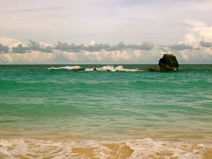 Horseshoe Bay: a fine art photograph of Bermuda seascape with sand, turquoise ocean water, cloudy sky, and large rock