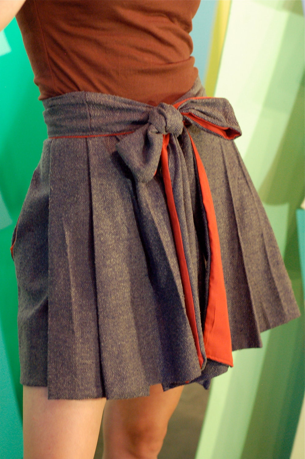 herringbone gets a bow --wrap skirt, front pleating, side pockets, red cotton liner, snap closure. bow skirt.