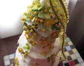 Rapunzel  Tiered CAKE TOPPER - yellow, spring green tiny flower embellishment atop 3 tiers of crisp white linen