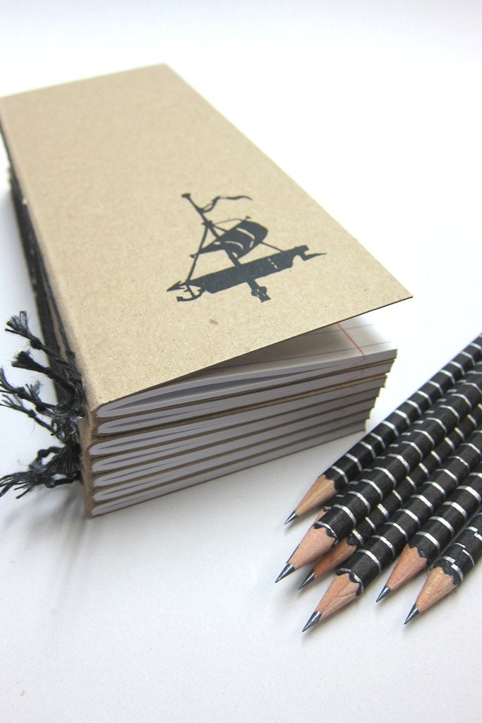 Notebook with a Sailing Ship and a Pencil