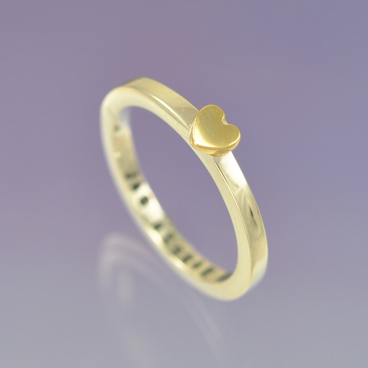 9k yellow gold heart atop a sterling silver ring. Personalised with your message inside.