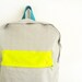Light grey with thin stripes backpack with neon yellow pouch