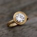 Moissanite and 14k Yellow Gold Engagement Ring, Matte Gold and MIlgrain Textured Bezel