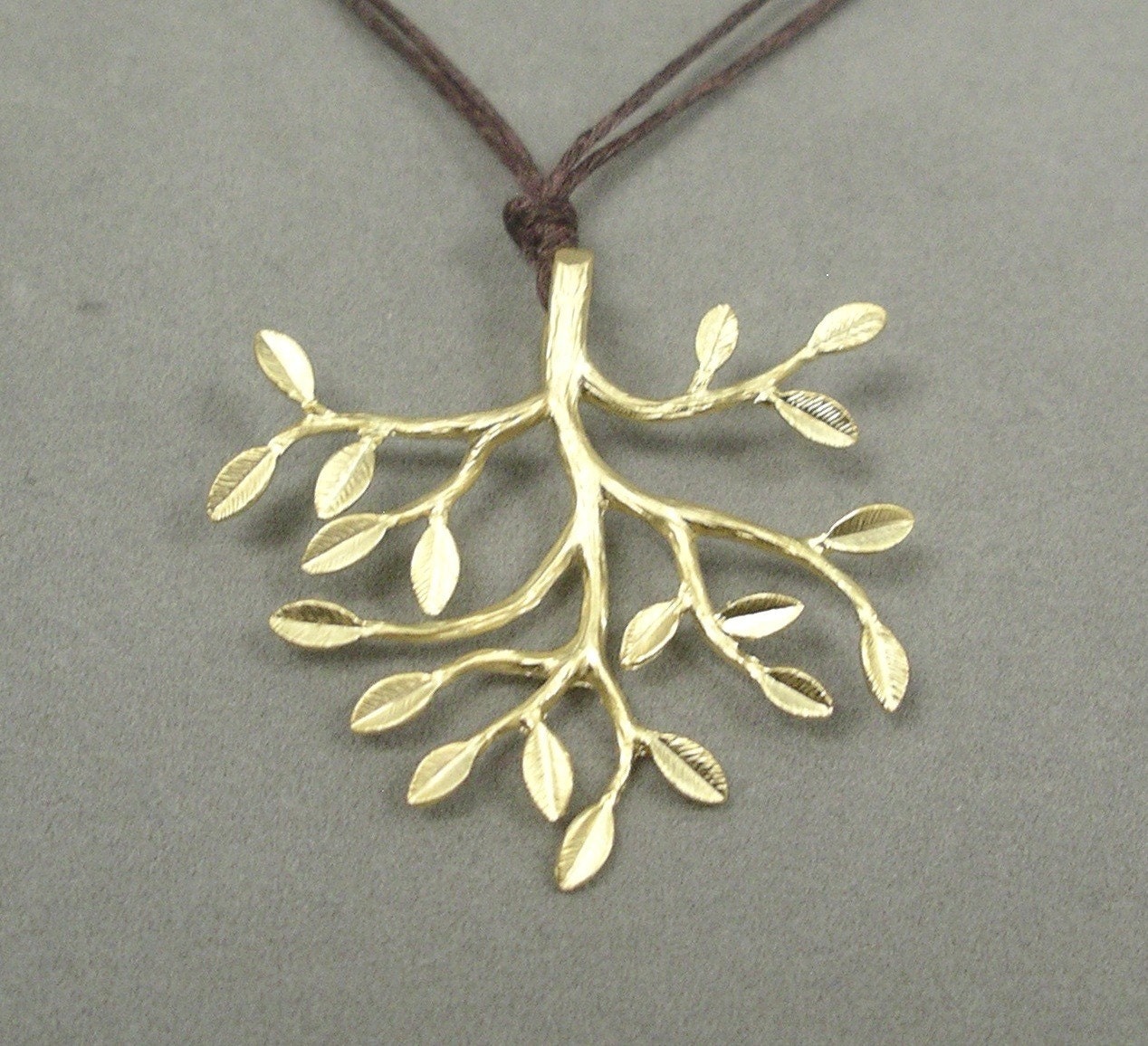 gold tree on brown cord necklace by rockedjewelry