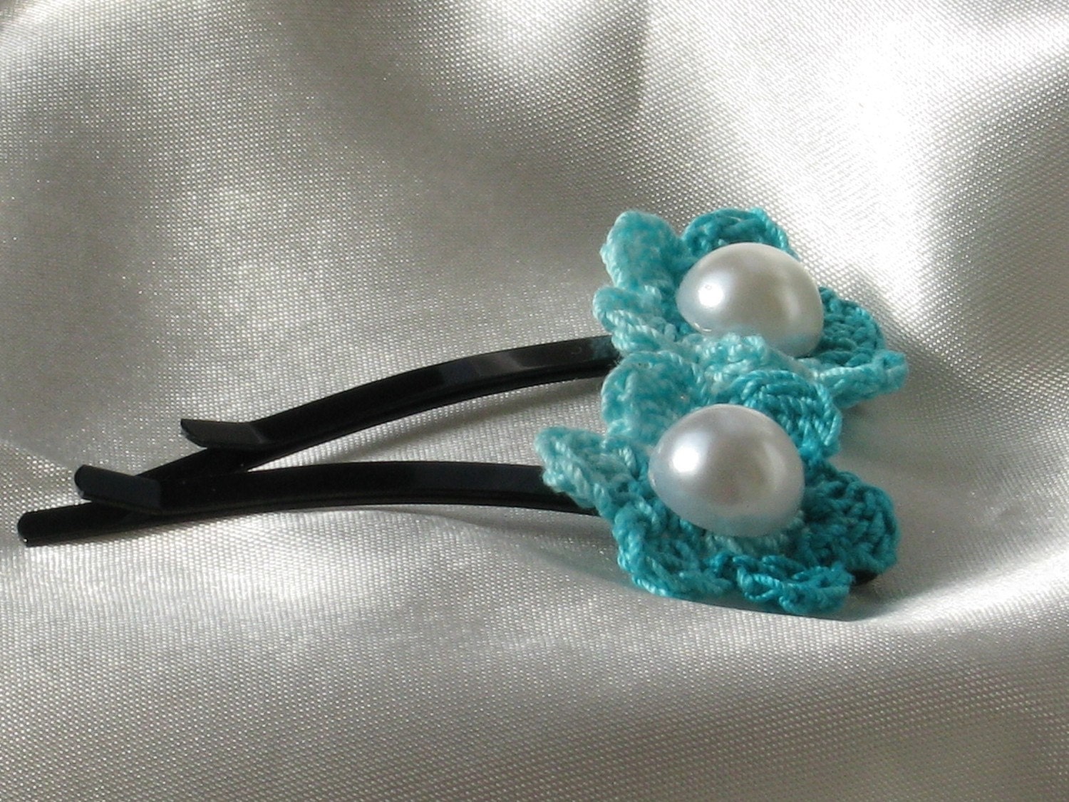 2 knitted bobby pins with turquoise flowers