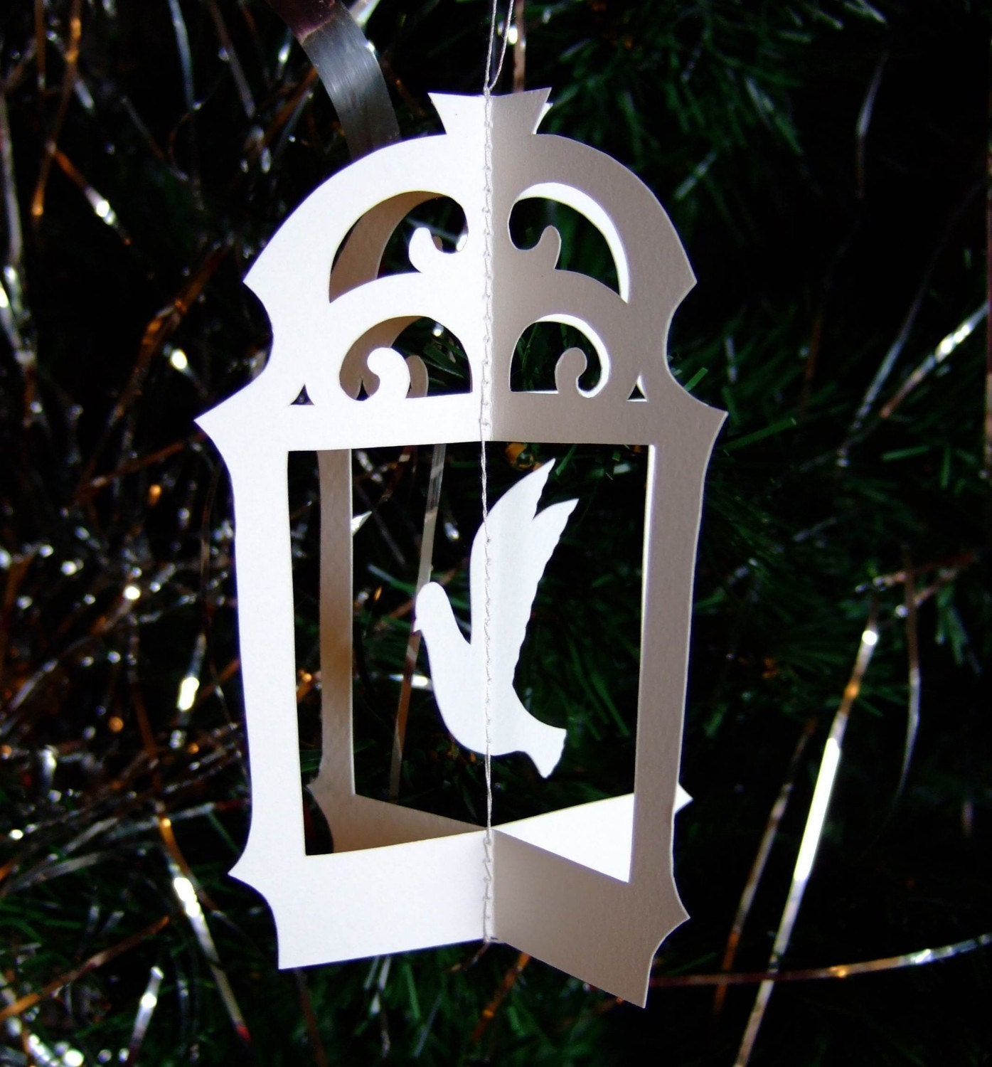 Original hand cut papercut of flying bird in cage - ivory