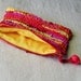 Zippered pouch crocheted in sunset stripes from colorful eco-friendly upcycled yarn, 7.5" by 5.5", red orange yellow pink coral