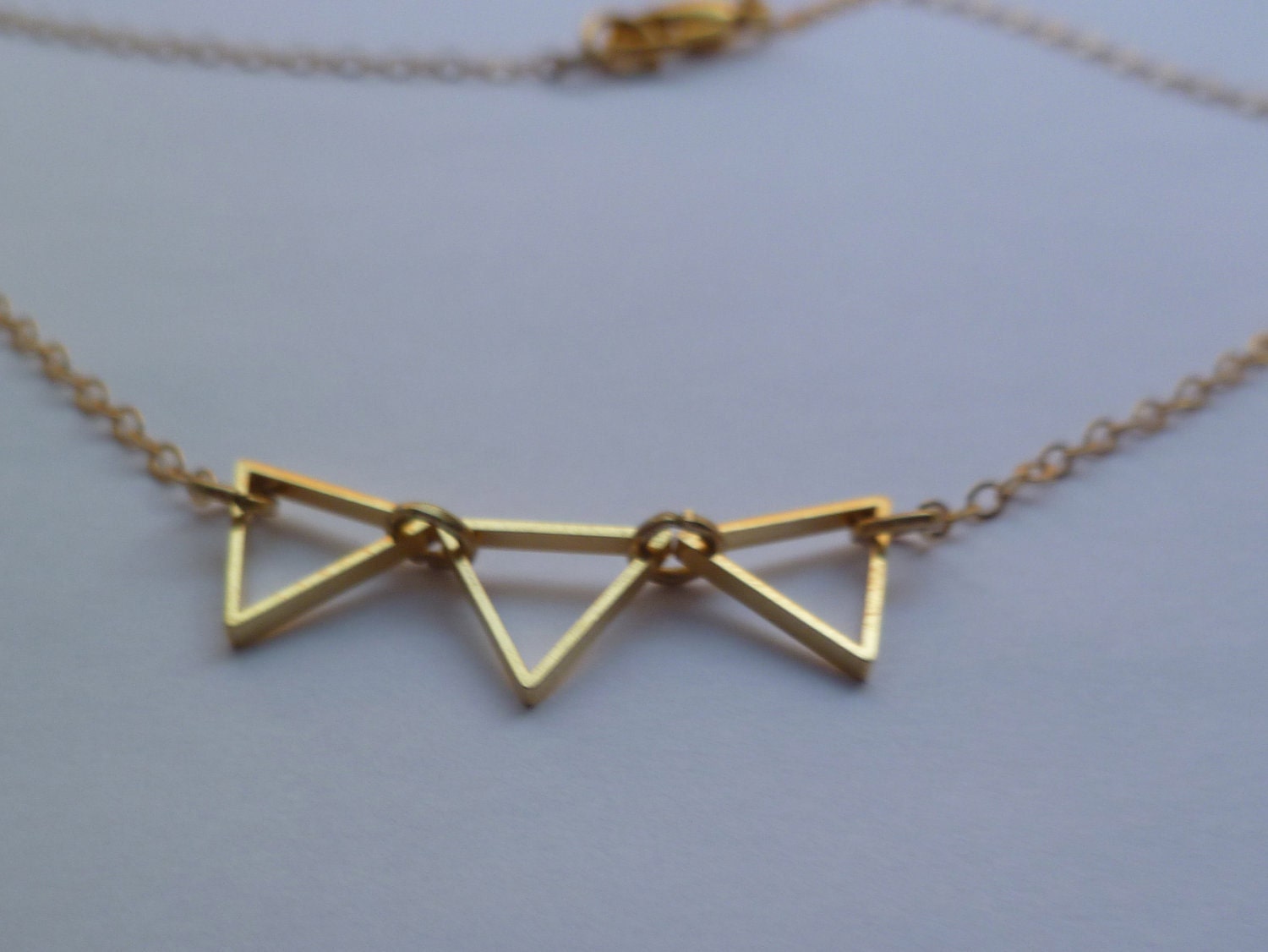 Tiny bunting necklace, three mini outline triangles in golden on thin gold fill chain