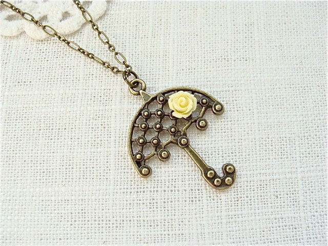 Antique brass umbrella necklace with a small yellow rose.