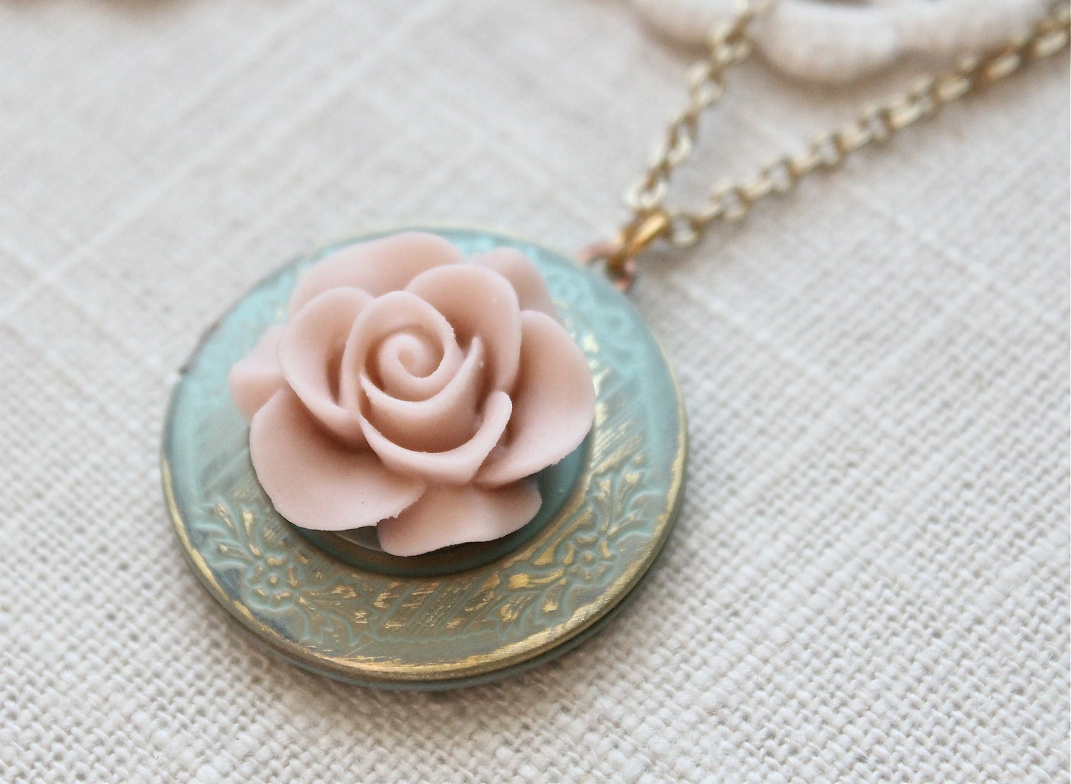 Weathered vintage style locket necklace.  Antique blue with a pale pink blooming rose.