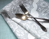 Pearl gray lace medallion on white linen table runner