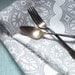 Pearl gray lace medallion on white linen table runner