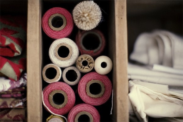 Tools Of The Trade, vintage thread bobbins with soft reds, cotton fabric stacked in an antique wooden cabinet 8X10 Fine Art Print