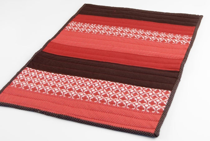 Modern Cat Mat: mini quilt in modern red and brown patterned stripes with off-white on back