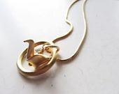 Golden origami paper crane eternity circle pendant necklace.  Gold snake chain.