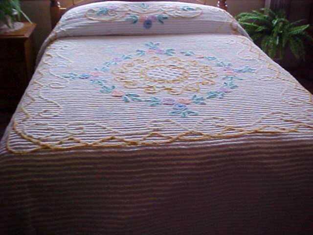 White Chenille bedspread with circle of multi-color flowers- 100X90 inches.
