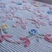 Soft pink and blue flowered Chenille bedspread on white