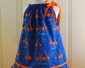 Organic cotton pillowcase dress with cute dancing giraffes and ruffled hem and orange ribbon trim