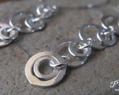 Simple lightweight sterling silver dangle earrings.  Contemporary organic shiny circles & rings.  Long, modern classic jewelry. Cashmere.