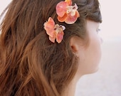 Two small orange orchid barrettes