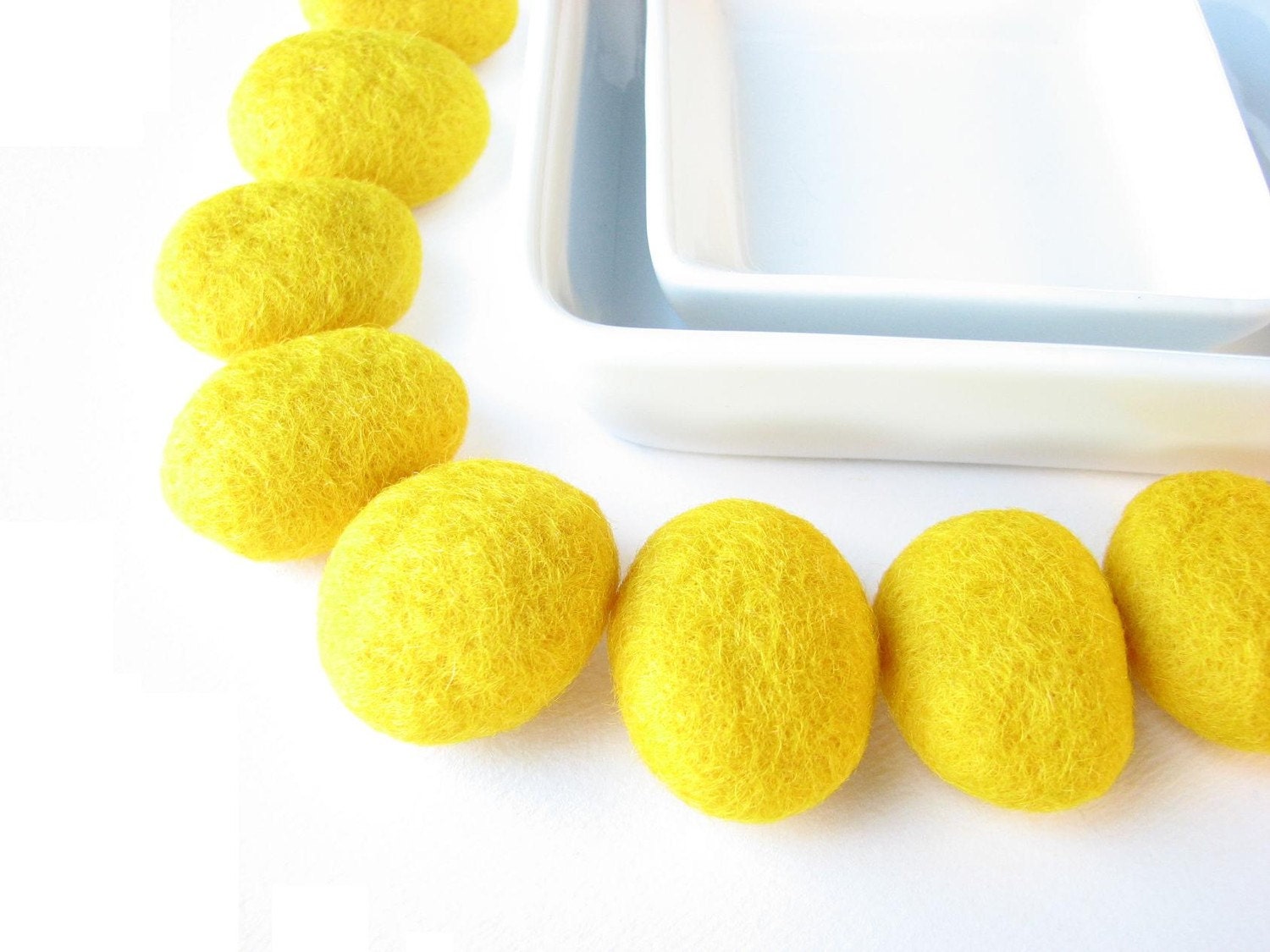 8 flat felted wool pebbles / beads  (yellow). Perfect for room decoration.