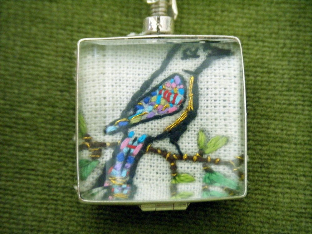 Hand embroidered art piece 'Love birds' in a two sided glass locket , Sterling Silver.