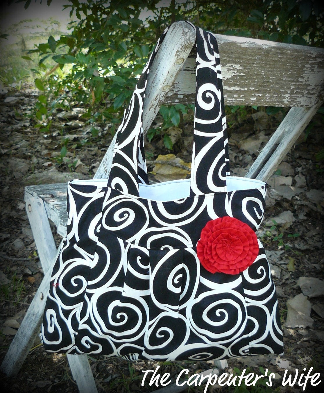 Pleated black and white swirls purse with red rosette