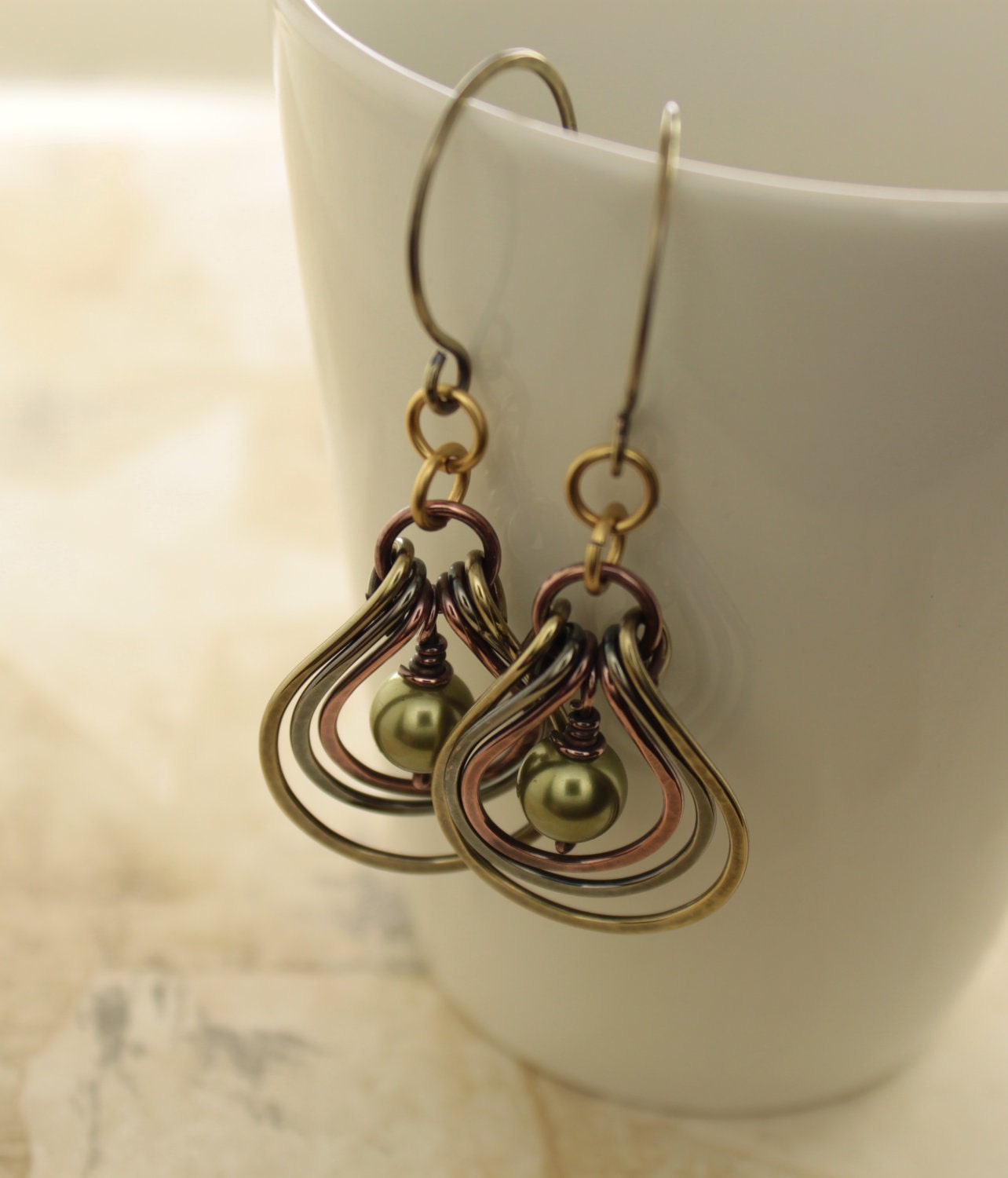 Multicolored metal earrings with copper, German silver and brass hoops with green Swarovski pearls