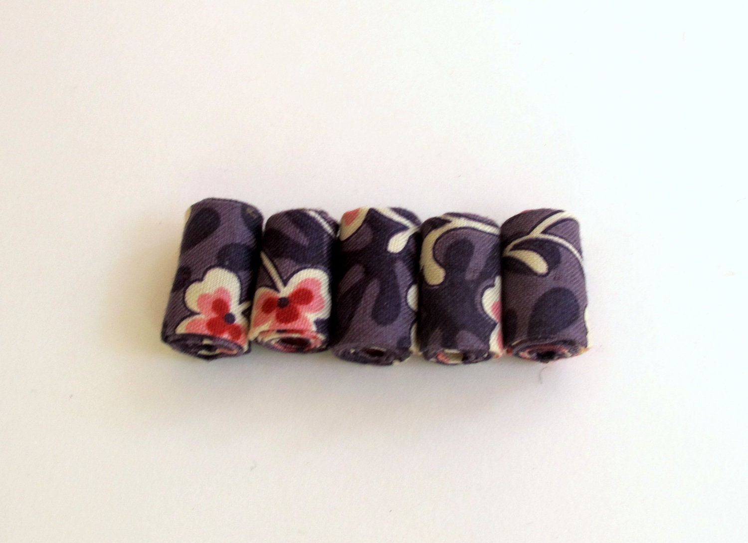 Hand rolled fiber beads in purple clover printed cotton