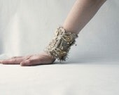 Tattered, asymmetrical, hirsute cuff from linen with beads and string.
