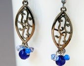 Blue Filigree earrings with a long oval gun metal dangles with floral motifs and carved cobalt blue glass beads and sparkly crystals, noir