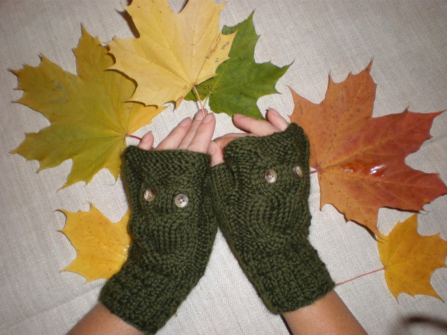Hand-knitted green wrist warmers with knitted owl