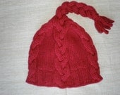 Hand-knitted dark red hat with cables and tassle
