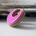 pink recycled wood reversable pendant on a wire necklace
