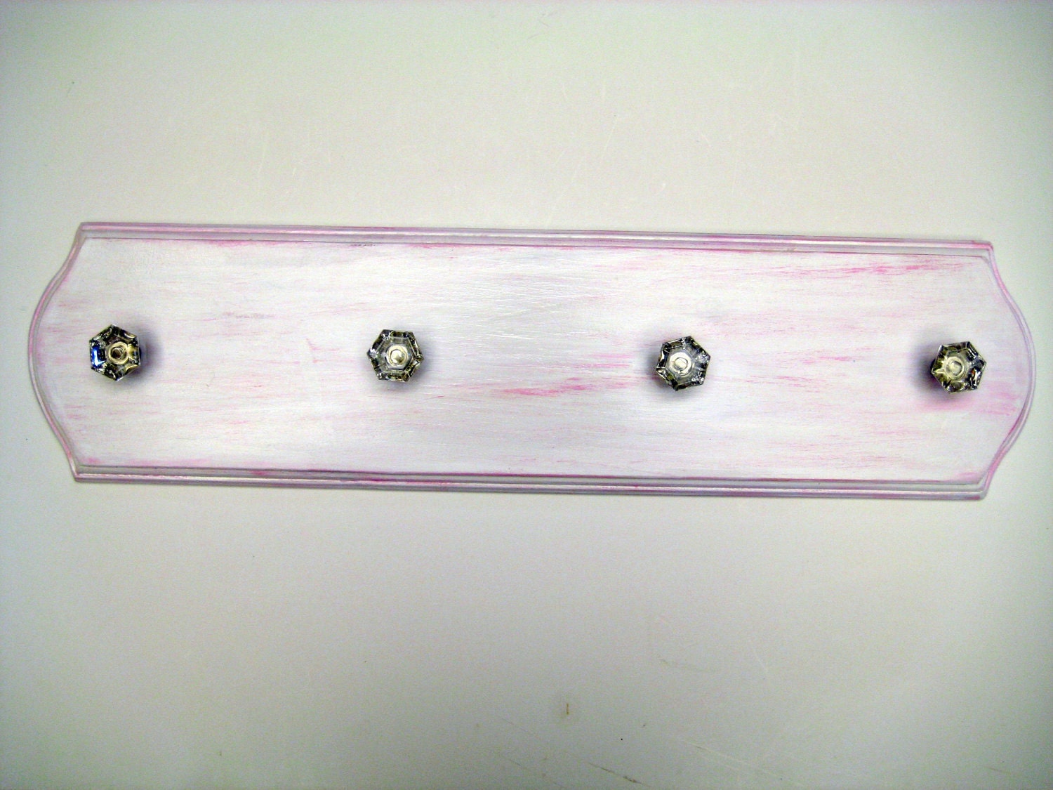 hand painted wooden plaque with a distressed pink finish with 4 crystal hooks