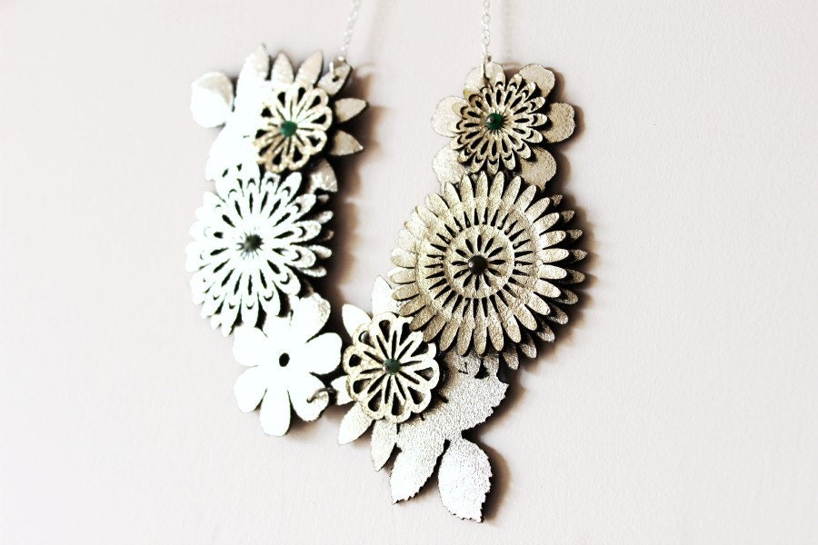 Gold Flower Necklace on a Brench with Tiny Emeralds