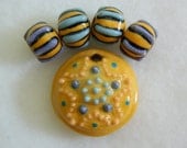 Starfish bead set in porcelain clay in yellow, orange, blue and purple