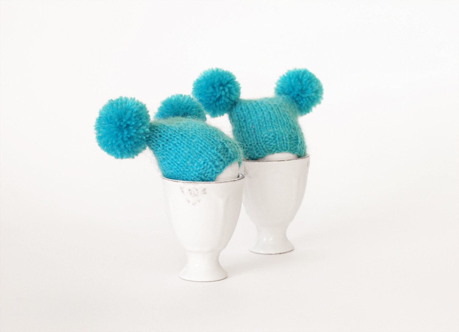 Turquoise egg warmers with funny poms