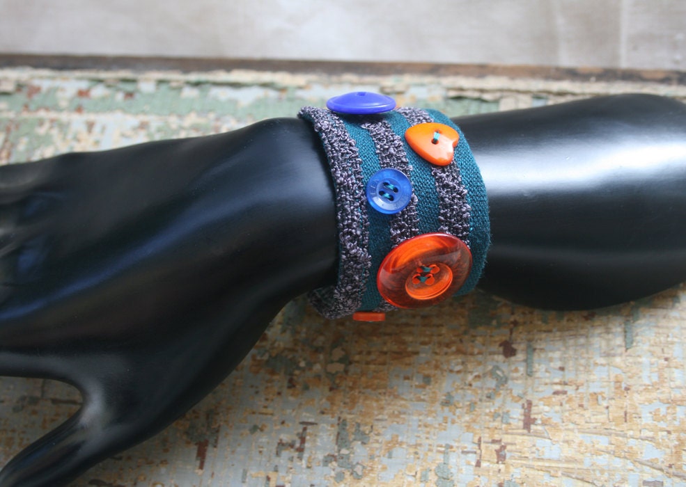 Blue striped bracelet with blue, orange, and teal vintage buttons