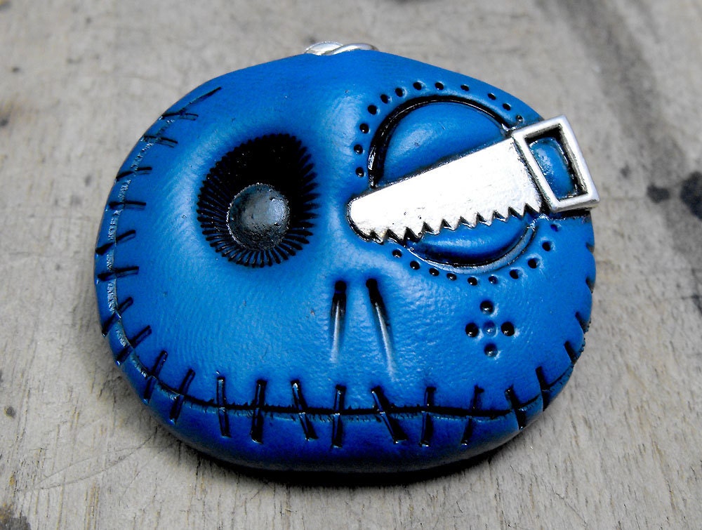 Navy blue skull keychain with a metal saw in his eye. Cute mini monser in deep blue