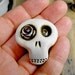 Mini sugar skull brooch with a lovely light pink rose his eye. A little bit dirty flower from any creepy cementery. Ha, ha, ha...
