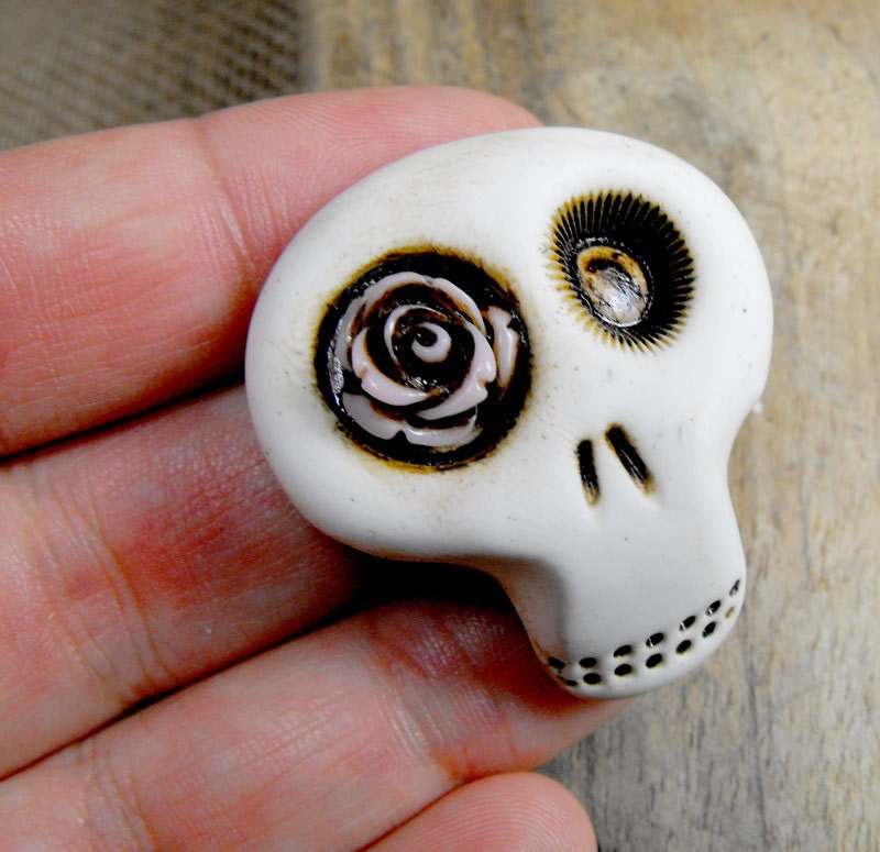 Mini sugar skull brooch with a lovely light pink rose his eye. A little bit dirty flower from any creepy cementery. Ha, ha, ha...