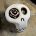 Mini sugar skull brooch with a lovely light pink rose his eye. A little bit dirty flower from any creepy cementery. Ha, ha, ha...