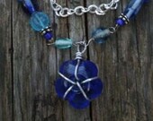 Blue glass bead necklace with wire wrapped flower pendant